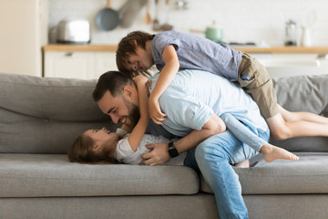 Happy father playing with two little kids at home