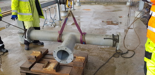 riggers move the pipe using two chain blocks