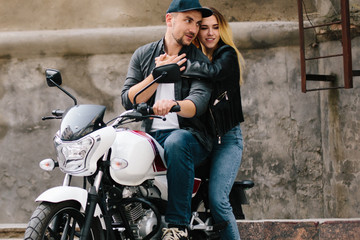 Fototapeta na wymiar Couple on motorbike near old building