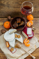Red Wine and camembert, brie, gouda cheese served on the table