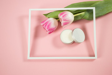 Spa accesories on the wodden background with some tulips and facial cream