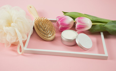 Fototapeta na wymiar Spa accesories on the wodden background with some tulips and facial cream
