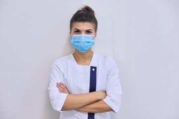 Portrait of confident young female medic in medical mask