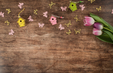 Spring background with tulips , frame and butterflies on the wooden background