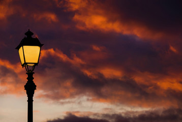 Old fashioned street lamp against beautiful sunset sky and colorful clouds (with copy space)