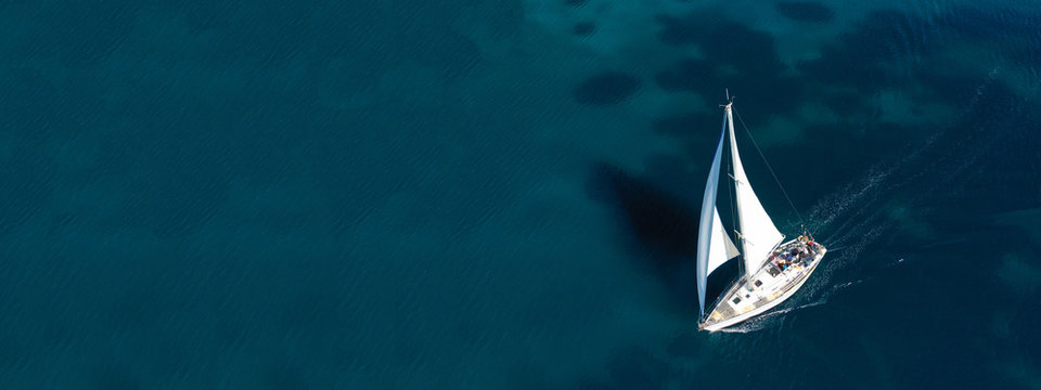 Aerial drone ultra wide photo of beautiful sail boat sailing in tropical exotic bay with emerald clear sea