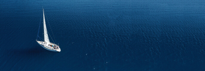 Aerial drone ultra wide photo of beautiful sail boat cruising in Aegean deep blue sea