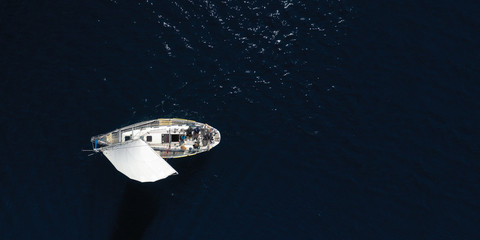 Obraz na płótnie Canvas Aerial drone photo of beautiful sail boat cruising in deep blue open ocean sea