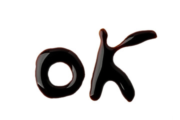 OK lettering made with chocolate syrup and isolated on white background