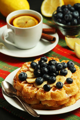 Belgian waffles with blueberry and a cup of tea with lemon
