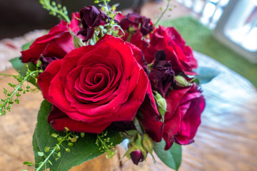 A small vase of red roses and other flowers form a decorative centrepiece.