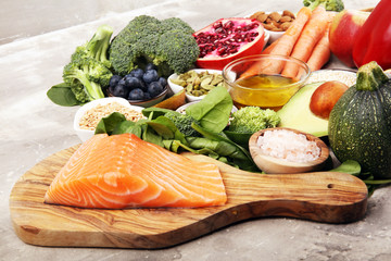 Healthy food clean eating selection: fish, fruit, vegetable, cereal, leaf vegetable on rustic background