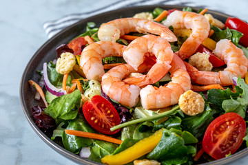 Fresh shrimp and greens salad on light background