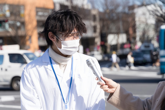 インタビュー　マスクとゴーグルの男性　白衣　医療関係者　イメージ