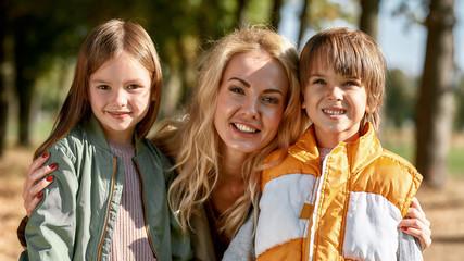 Loving family. Portrait of happy beautiful mother and her children hugging and looking at camera...