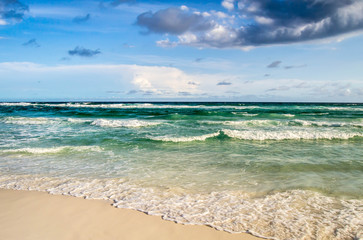 Deep colored ocean waves rolling onto shore