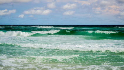 Deep green waves rolling into shore