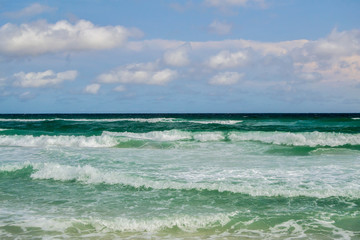 Deep green waves rolling into shore