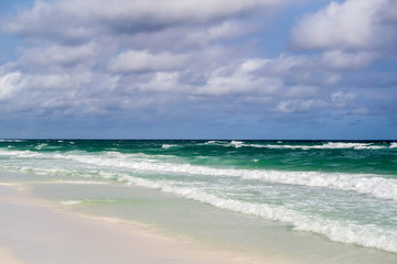 Deep colored ocean waves rolling onto shore
