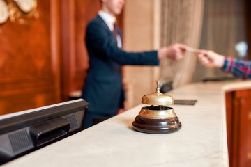 Always hear you. Young executive at the reception desk of a hotel working in the background. Focus...