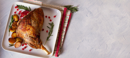 Roast leg of lamb with potatoes, pomegranate and rosemary. View from above, top view, copy space