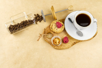 coffee cup with a gold border on olive wood board. Breakfast setting, coffee oatmeal cookies with raspberries and mini tosca cake