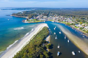 Obraz premium Aerial drone view of boats and yachts moored on Currambene Creek at Huskisson, Jervis Bay on the New South Wales South Coast, Australia, on a bright sunny day 