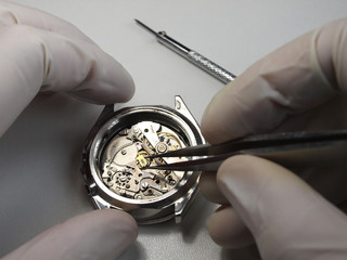 close up of watchmaker working on vintage chronograph mechanism
