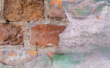 Old weathered brick wall. Peeling cracked paint on red brick