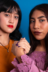 two young latin women holding hands for gender equity