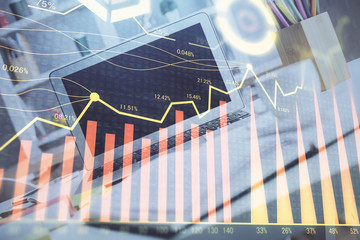 Stock market graph on background with desk and personal computer. Double exposure. Concept of financial analysis.