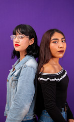 Two latin young ladies posing back to back