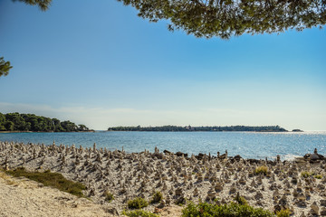 Rovinj beach covered with stacked stones creating one of the most interesting beaches in Istria Croatia named Golden cape
