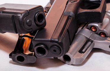 Obraz premium Four handguns, two black pistols a 9mm and a 40 caliber with a black revolver, 38 special and a silver one, 357 magnum on a white background