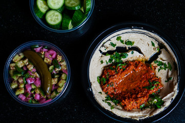 Muhammara hummus with salad and cucumber slices.