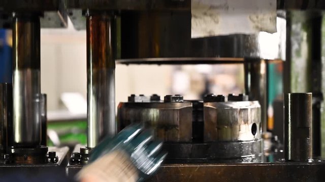 Woman operator stamping metal pieces by pressing machine, metal pressing machine .