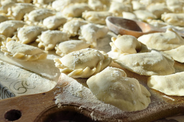 Fototapeta na wymiar Dumplings, ravioli with cheese are on the kitchen table