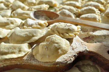 Fototapeta na wymiar Dumplings, ravioli with cheese are on the kitchen table