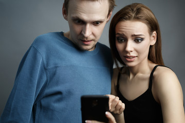 Man with woman is looking at smartphone