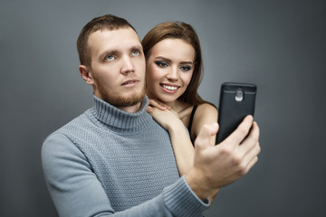 Guy and girl are taking pictures of themselves