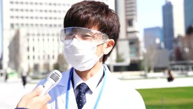 インタビュー　マスクとゴーグルの男性　白衣　医療関係者　イメージ