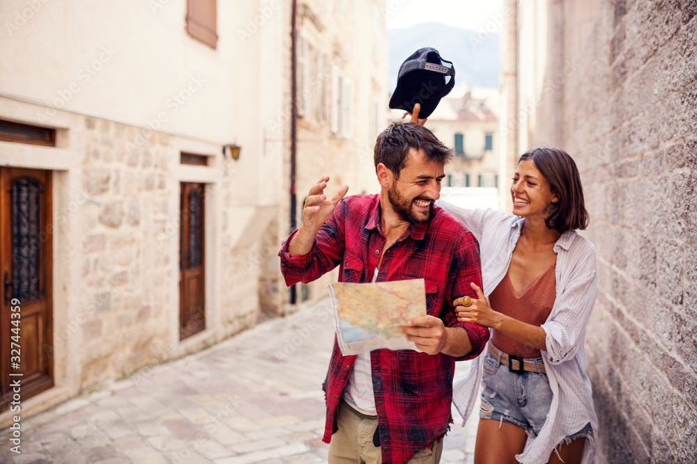 Wall mural sweet young couple using map in town