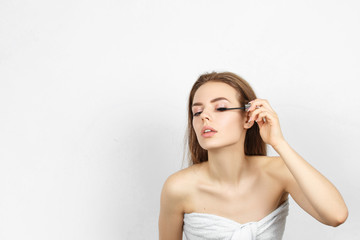 Fototapeta premium Beautiful woman in a towel making makeup