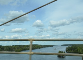 blurry metal railing and cable on bridge and river water