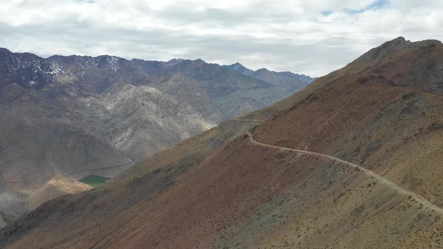 An aerial view inside Andes mountains at Limari Valley, south Atacama. An amazing wild scenery. Arid idyllic valleys with green farm fields feed in by the river at the bottom of the valley
