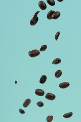 Falling coffee grains on a light background. Texture for design. Freezing in motion.