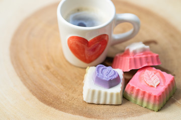 Coconut milk jelly, cup coffee on textured wooden tray.