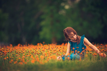 A young girl laughing in a field of summer flowers