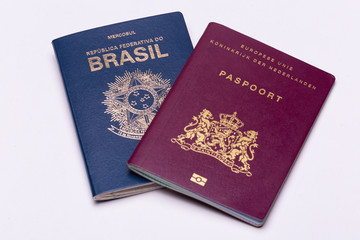European - Dutch - on top of a Brazilian international passport a bright surface background. Concept double nationality.