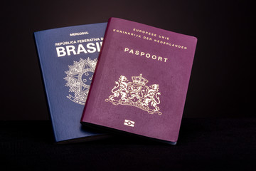 Brazilian and European - Dutch - passport on a dark background. Concept double nationality.